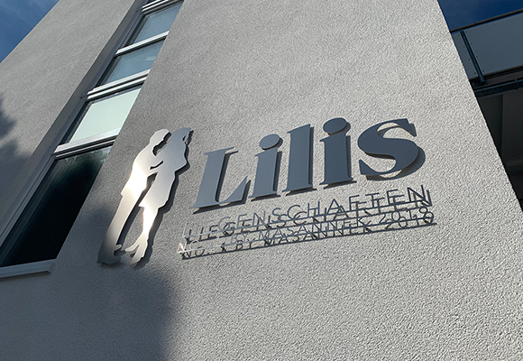Fassadenschild: Lilis Liegenschaften in Munster